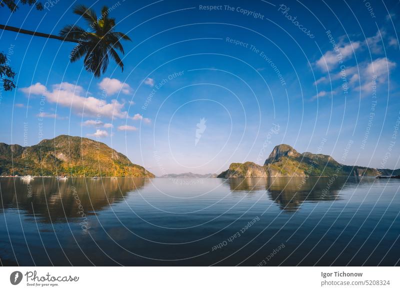 Sonnenaufgang in der Bucht von El Nido. Insel im Ozean, beleuchtet vom warmen Morgenlicht. Palawan, Philippinen tropisch schön Silhouette Natur reisen Wasser