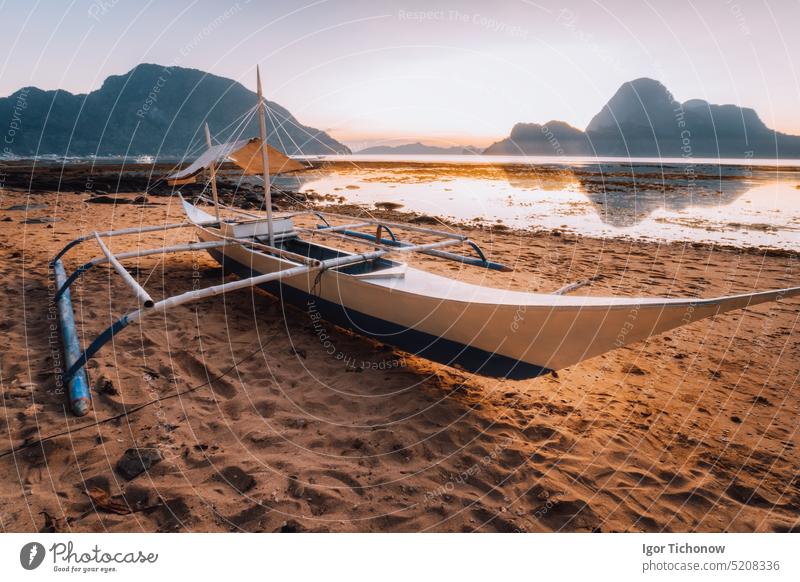 Boot am Strand in der Bucht von El Nido. Schöne Landschaft mit Ozean Lagune im Sonnenuntergang Licht, Palawan, Philippinen reisen Urlaub Dämmerung el nido