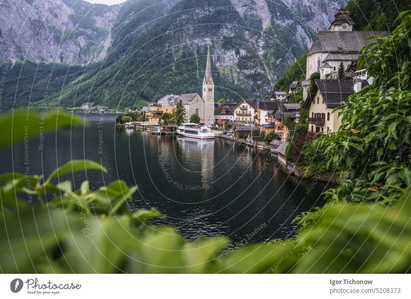 Berühmte Seeseite Ansicht von Hallstatt Dorf mit Alpen hinter, Laub Blätter gerahmt. Österreich berühmt Stadt Landschaft Natur Tourismus Architektur Europa