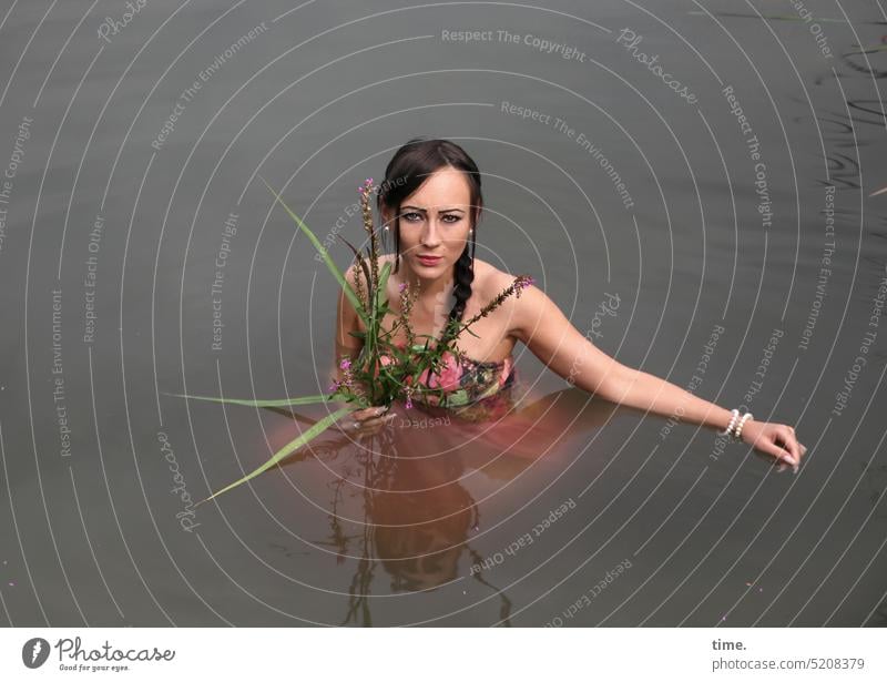 Frau mit Blumen im See weiblich baden Blick Erholung Portrait Oberkörper Kleid Zopf Langhaarig dunkelhaarig schauen skeptisch