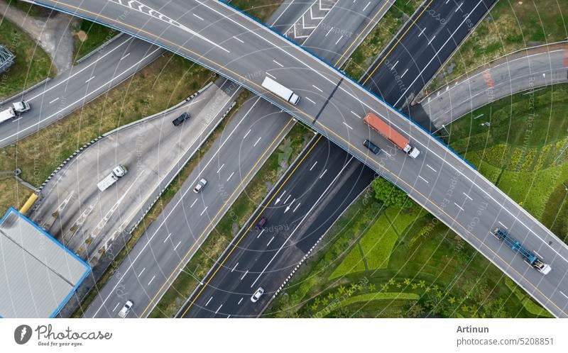 Luftaufnahme der Autobahnkreuzung und des Autobahnkreuzes. Drone Blick auf die erhöhte Straße, Verkehrsknotenpunkte, und grünen Garten. Transport Lastwagen und Autos fahren auf der Autobahn. Infrastruktur in der modernen Stadt.