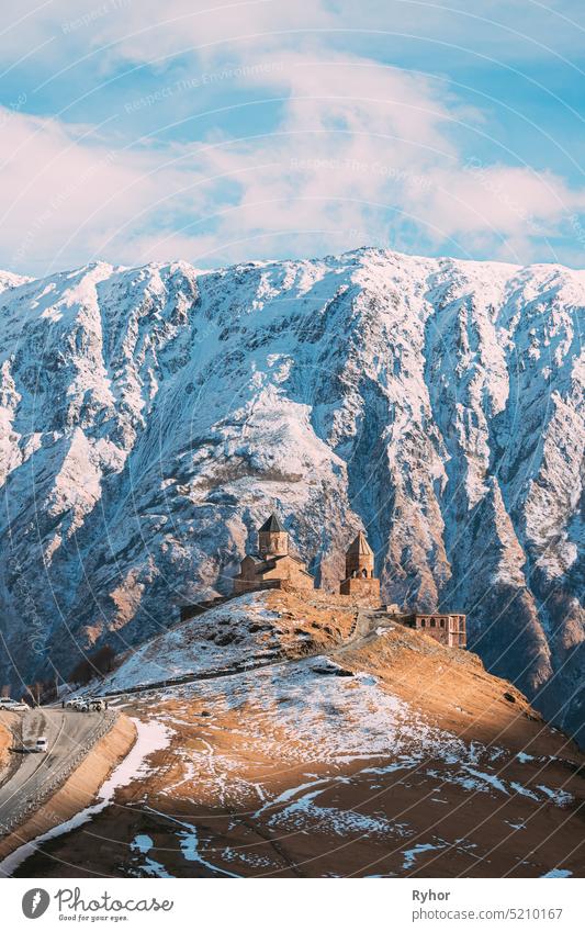 Stepantsminda, Georgien. Berühmte Gergeti Trinity Tsminda Sameba Kirche im frühen Winter Landschaft. Schöne georgische Berge Landschaft heilig reisen Ansicht