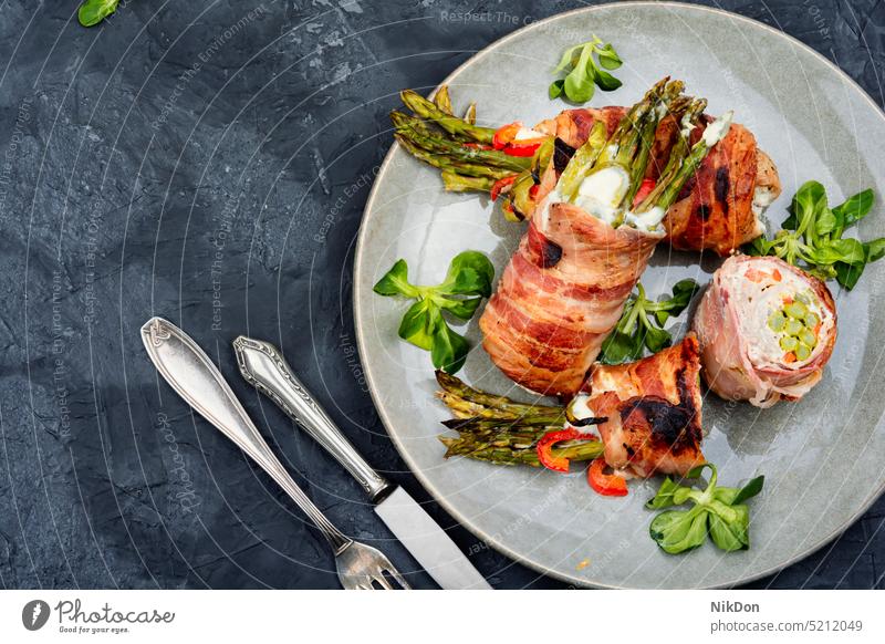 Gebratene Fleischrolle, gefüllt mit Spargel. Hackbraten rollen eingewickelt Speck Rindfleisch Roulade gegrillt Lebensmittel gebraten Gemüse Teller lecker