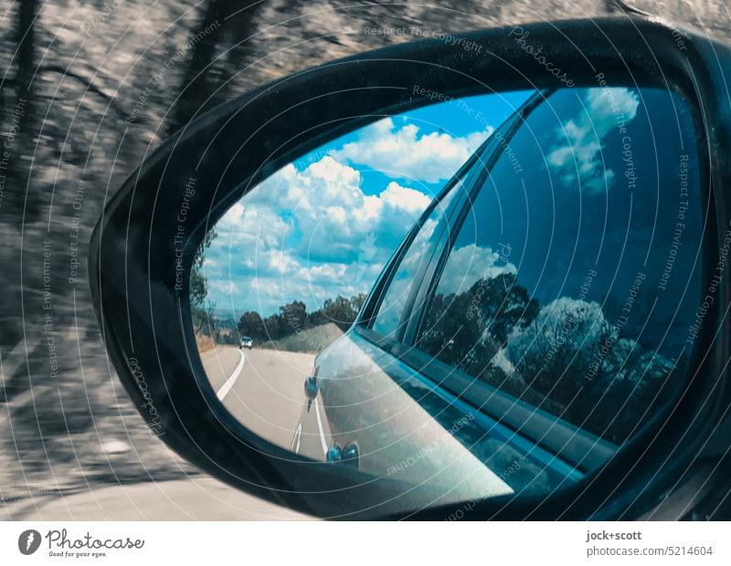 Autofahrt auf dem Freeway und Wolken im Rückspiegel Außenspiegel Spiegel PKW Straße Autofahren Verkehrswege Verkehrsmittel Fahrzeug Mobilität Linksverkehr