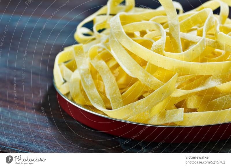 Rohe Fettuccine-Nudeln auf einem Teller Spätzle Lebensmittel Küche Textfreiraum Gesundheit Essen zubereiten Studioaufnahme Tagliatelle Bestandteil Hintergrund