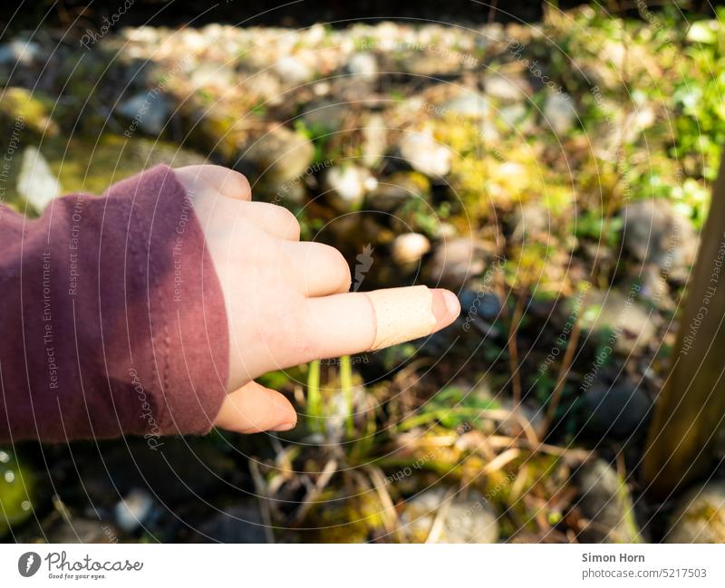 Kinderhand mit Pflaster Hand Verletzung Schmerz stolz zeigen Richtung verheilen Gesundheit Wunde Finger verletzt wehtun