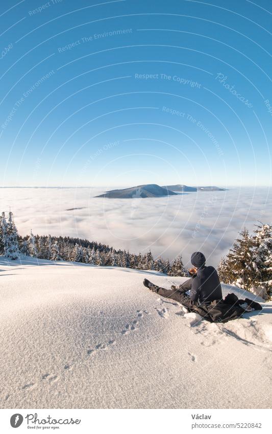 Bergsteiger ruhen sich auf einer Lichtung mit Blick auf die umliegenden Beskiden in der mährisch-schlesischen Region aus, nachdem sie den Lysa Hora bestiegen haben. Das Frühstück bei Sonnenaufgang über den Wolken genießen