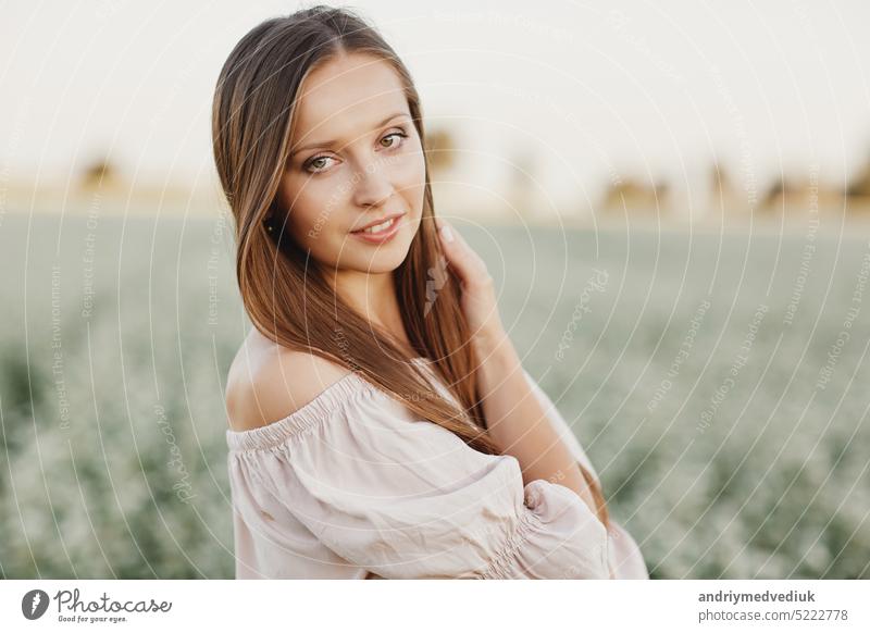 Schöne Frau genießt Feld, glückliche junge Dame und frühlingsgrüne Natur, Harmoniekonzept. Portrait eines schönen Mädchens in einem Blumenfeld. selektiver Fokus