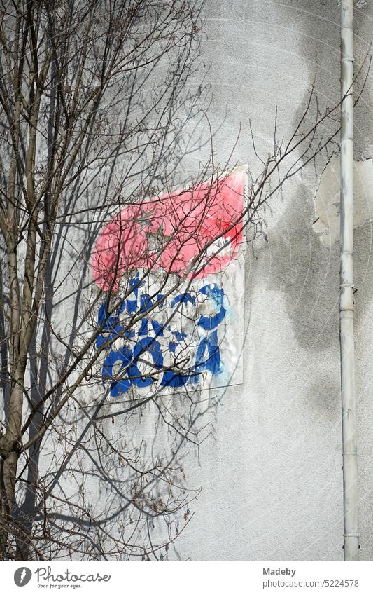 Vergilbtes Logo einer alten Getränkekarte an der Fassade in Naturfarben einer alten Fabrik im Frühling bei Sonnenschein in Detmold am Teutoburger Wald in Ostwestfalen-Lippe