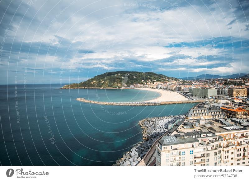 Strand mit Stadt und Hügel im Hintergrund Sonne Häuser Meer Wasser Sand Sommer blau Natur Bucht donostia san sebastian Spanien San Sebastián Baskenland