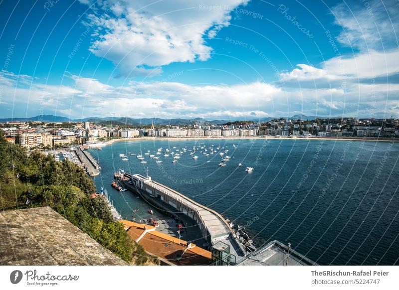 Strand mit Häuser im Hintergrund von oben Sonne Hügel Meer Wasser Sommer blau Natur Bucht donostia san sebastian Spanien San Sebastián Baskenland Landschaft