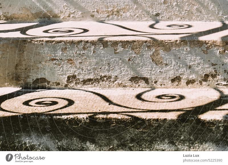 Schnecken Schatten vom Schmiedeeisengeländer auf der alten Treppe Schnörkel rund schön Geländer weiß hell Kontrast Sonne Licht Schattenspiel Sonnenlicht