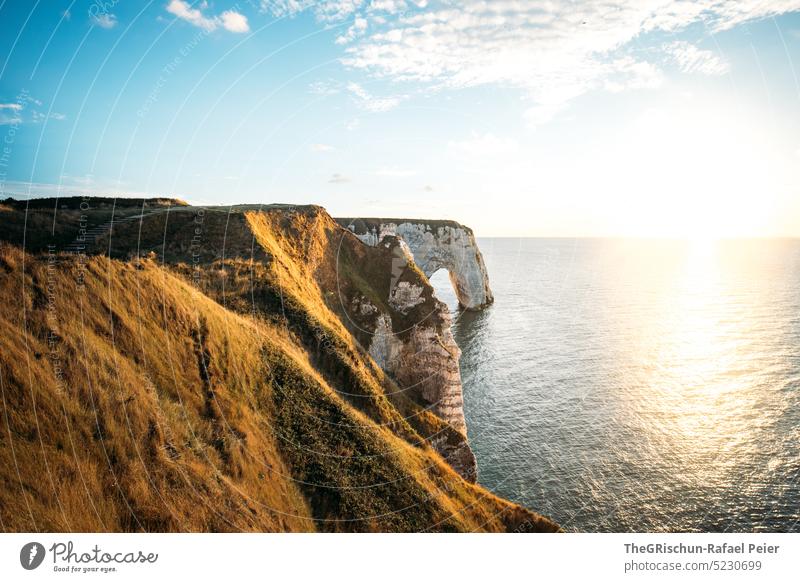 Küste mit Felsen und Meer im Sonnenuntergang Steinstrand Frankreich Normandie Étretat Stimmung Abendstimmung Wolken Klippen Landschaft Natur Außenaufnahme