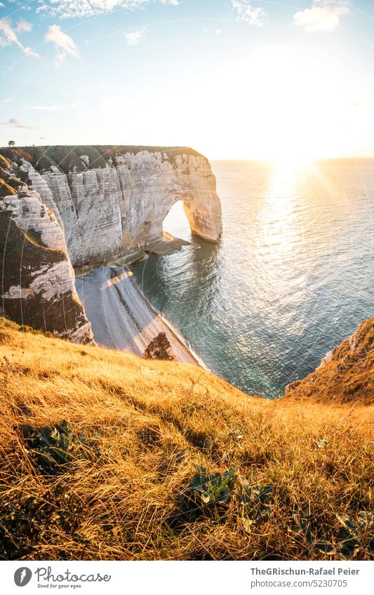 Küste mit Felsen und Meer im Sonnenuntergang Steinstrand Frankreich Normandie Étretat Stimmung Abendstimmung Wolken Klippen Landschaft Natur Außenaufnahme