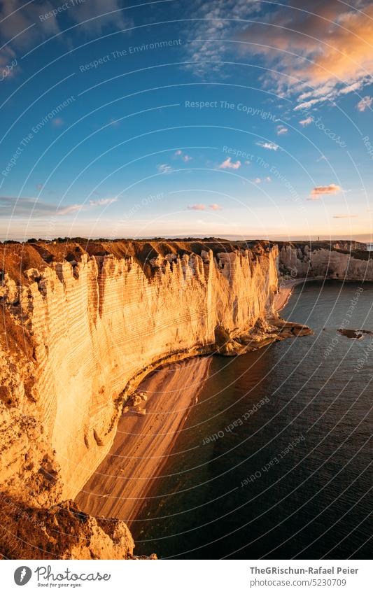 Küste mit Felsen und Meer im Sonnenuntergang Steinstrand Frankreich Normandie Étretat Stimmung Abendstimmung Wolken Klippen Landschaft Natur Außenaufnahme