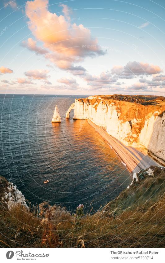 Küste mit Felsen und Meer im Sonnenuntergang Steinstrand Frankreich Normandie Étretat Stimmung Abendstimmung Wolken Klippen Landschaft Natur Außenaufnahme