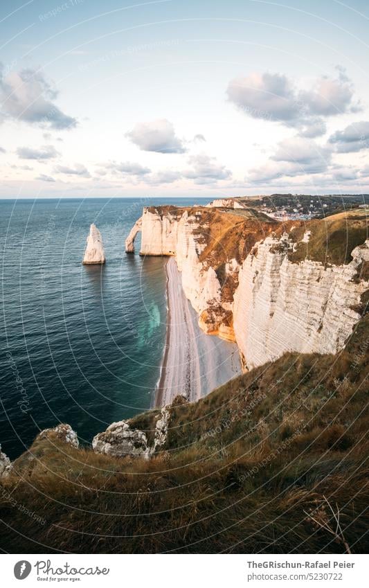 Küste mit Felsen und Meer im Sonnenuntergang Steinstrand Frankreich Normandie Étretat Stimmung Abendstimmung Wolken Klippen Landschaft Natur Außenaufnahme