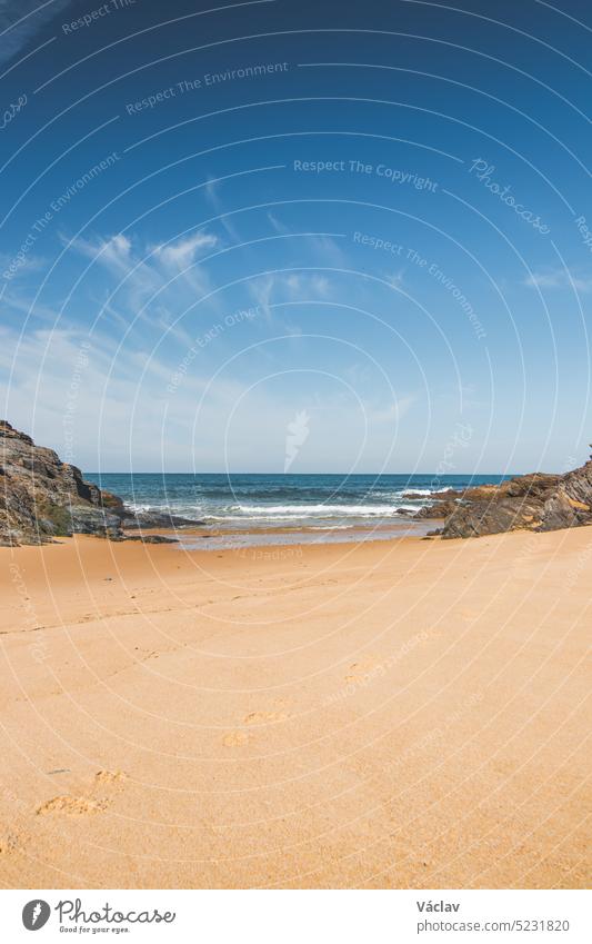 Spaziergang entlang des Atlantiks am Strand Praia da Ilha do Pessegueiro in der Nähe von Porto Covo, Westportugal. Schritte über die Rota Vicentina Sand