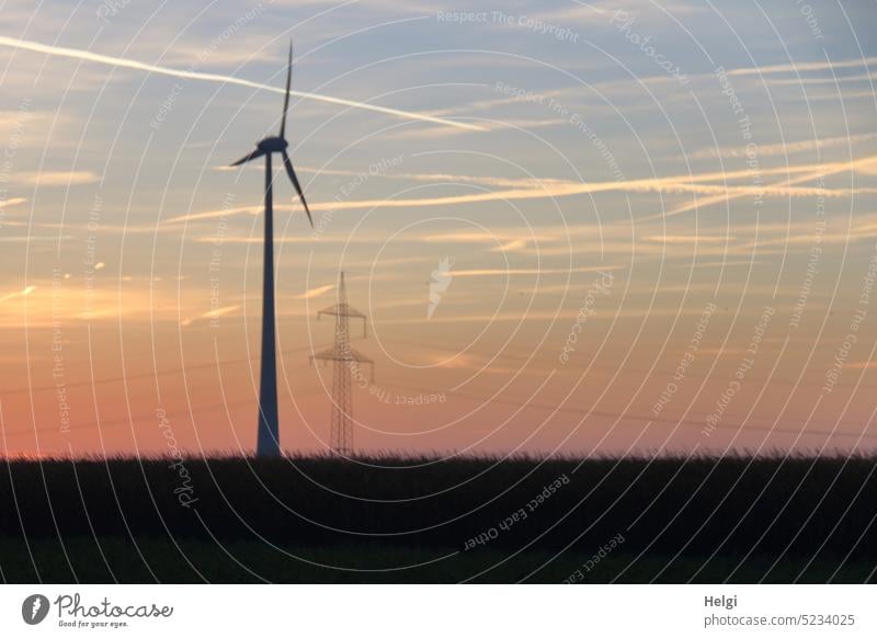 Bildstörung | Windkraftanlage und Strommast bei Sonnenaufgang, unscharf Windrad Stromerzeugung Energie Morgen Himmel Wiese Morgenröte Erneuerbare Energie