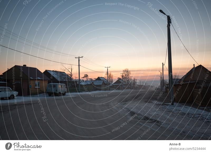 Dorfstraße in Sibirien bei untergehenden Sonne im Winter einfach eisig Kälte abends bittere Kälte draußen Winterabend arme Leute Leben im eisigen Winter