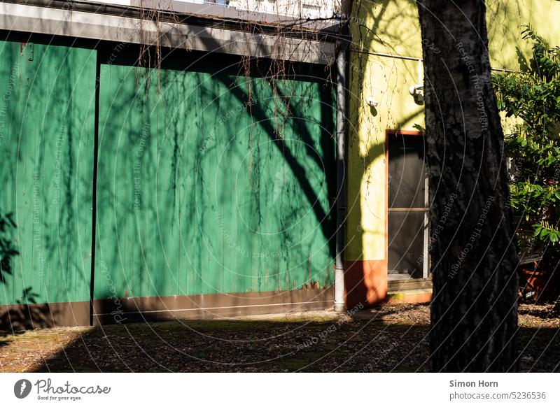 Im Schatten eines Baumes Schattenspender schattig Sonnenschutz Hinterhof Tor Unterschlupf Sonnenlicht Sommer Werkstatt Treffpunkt Schönes Wetter Erholung