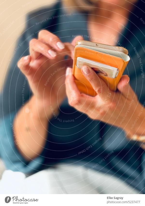 Zarte Frauenhände  an einem  Smartphone Hände feminin portrait weiblich halten langhaarig Porträt Mensch dunkelhaarig schmuck blick schauen