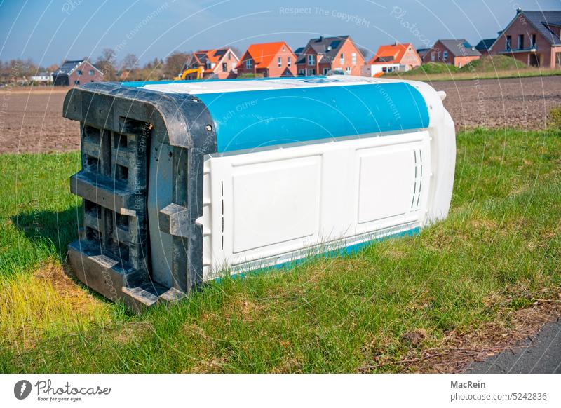 Umgefallenes Toilettenhäuschen an einer Straße WC Feldweg niemand keine person Klo