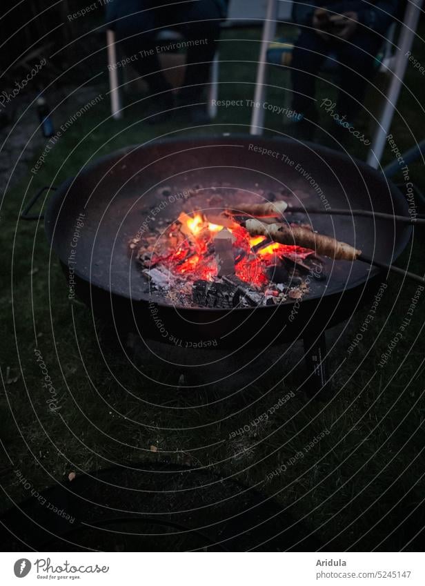 Feuerschale mit Glut und Stockbrot heiß Holz Feuerstelle Hitze Wärme glühend schwarz orange Flamme Brennholz Nacht Abend Treffen geselliges Beisammensein