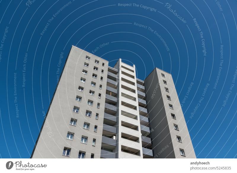 Freistehender grauer Wolkenkratzer mit klarem blauen Himmel Unterkunft Appartement Architektur Balkon unten groß Klotz Gebäude Großstadt übersichtlich wolkenlos