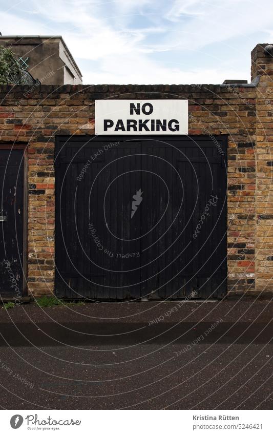 no parking kein parken nicht parken garage einfahrt ausfahrt parkplatz nein schild hinweis info forderung bitte straße draußen garagentor architektur gebäude