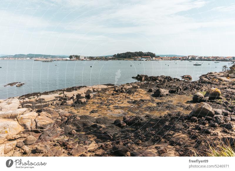 Felsenufer mit kleinen Fischerbooten Galicia Ufer Steine blau glänzend Meer reisen sanft Schönheit Küste Hintergrund winken Muster Strand Fluss Textur Brandung