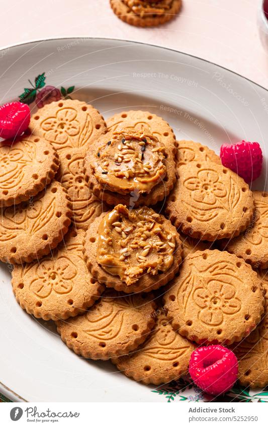 Leckere Kekse mit Erdnussbutter und Himbeeren werden auf dem Tisch serviert süß selbstgemacht lecker Dessert gebacken Biskuit Gebäck Teekanne appetitlich Samen