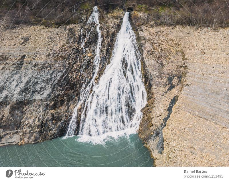 Panoramadrohnenaufnahme eines Wasserfalls, der in den Lac Chambon in den französischen Alpen fließt aktiv alpen alpen berge Almsommer Hintergrund Staustufe