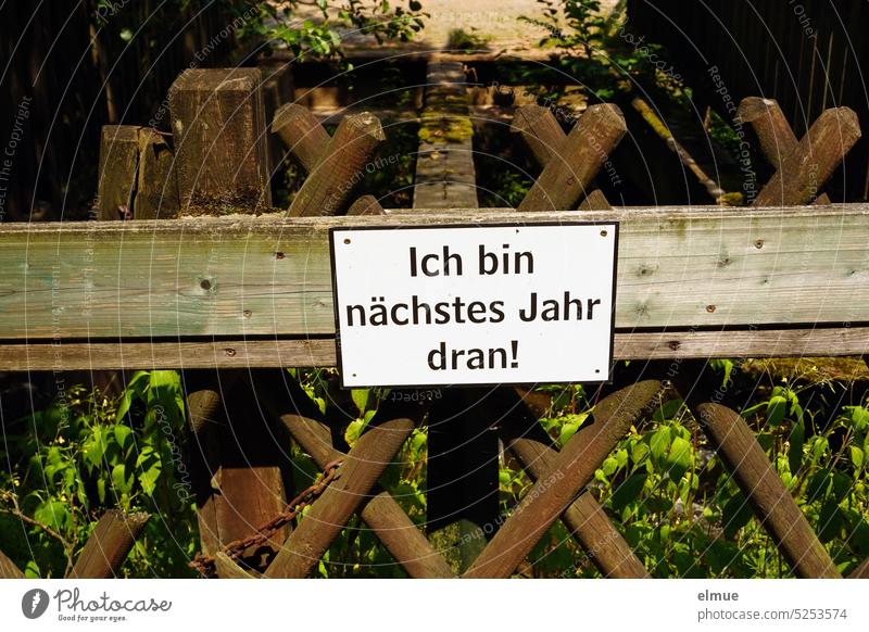 Schild "Ich bin nächstes Jahr dran!" an einem Holzzaun / Reihenfolge Vorsätze Plan Restaurierung Holzlatten Blog gute Vorsätze witziger Spruch