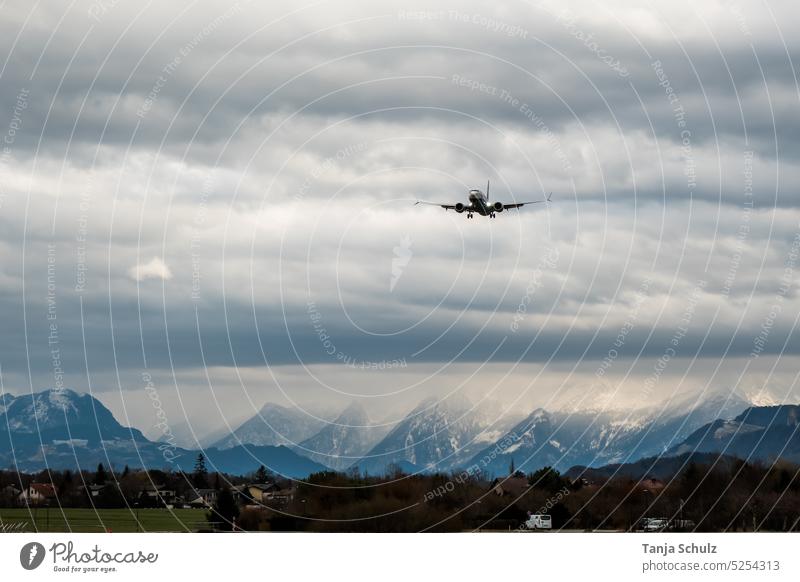 Flugzeug über Bergkette Landeanflug Himmel Wolken Flughafen Landung Flugzeuglandung Außenaufnahme Gebirge Passagierflugzeug Urlaub Freiheit fliegen Tourismus