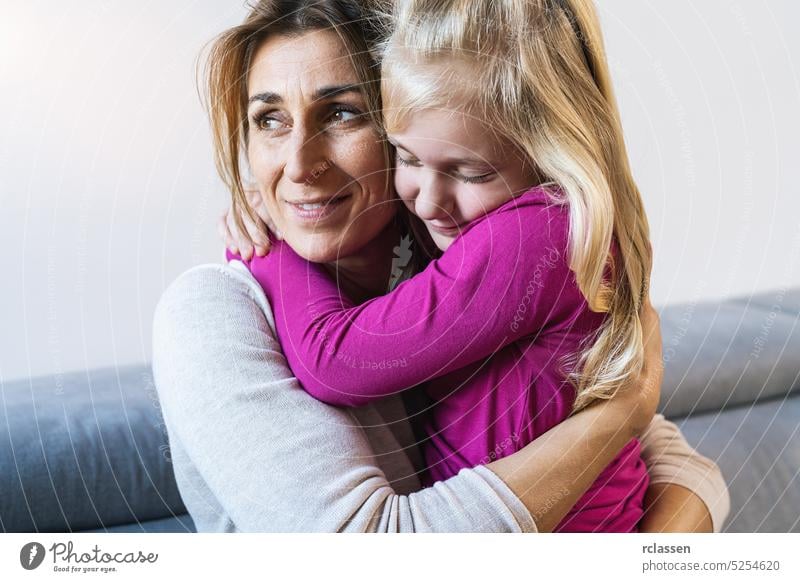 Mutter und ihre Tochter Kind Mädchen spielen und umarmen. Glückliche liebevolle Familie Konzept Bild Umarmung Wohnzimmer Sofa Mama Pflege Frau Lachen Eltern