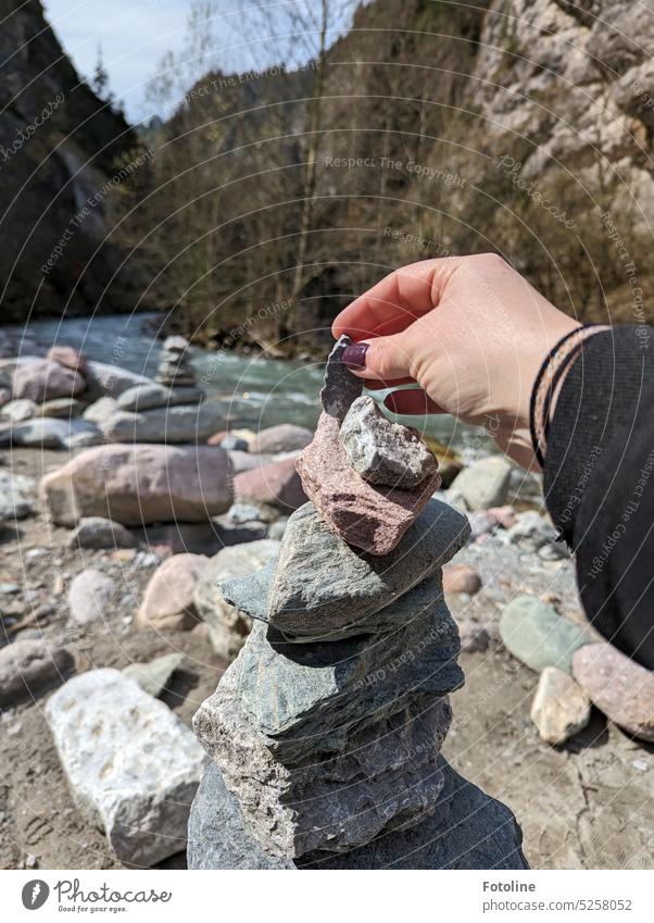 Stein auf Stein, so wachsen hier in der Kundlerklamm in Österreich kleine Steinhaufen. Gerahmt werden die kleinen Türmchen von hohen Bergen. Kieselsteine Türme