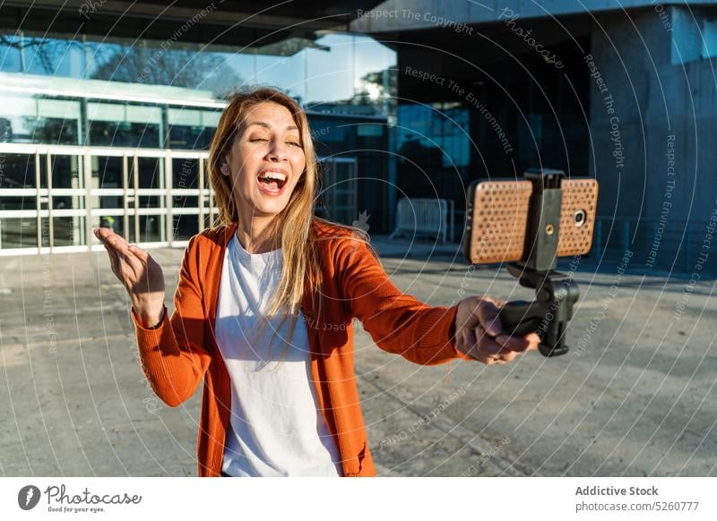 Junge Frau nimmt Selfie auf der Straße Smartphone Großstadt Lächeln Stil fotografieren urban jung brünett Glück blond heiter Moment Mobile Telefon lange Haare