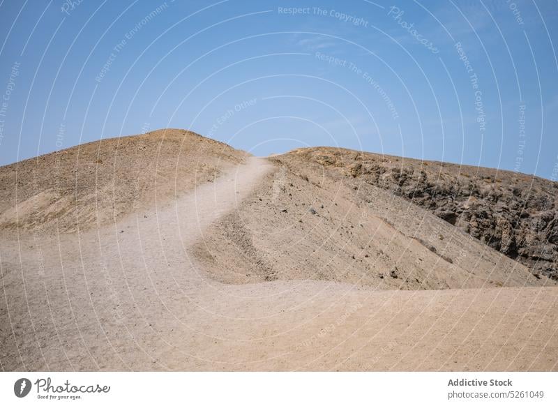 Felsige Klippe unter blauem Himmel felsig wolkenlos Sonnenlicht Sommer Landschaft Resort Lanzarote Papageienstrand Spanien Europa Natur Weg Felsen Stein