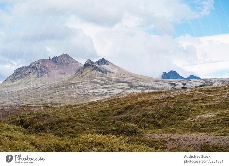 Dramatische Herbstberglandschaft unter bewölktem Himmel Berge u. Gebirge Ambitus wolkig Blauer Himmel Kamm Landschaft Natur atemberaubend Island Europa Tal Gras