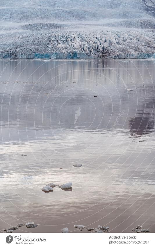 Malerische Landschaft mit See und verschneiten Hügeln an einem bewölkten Tag Natur Winter spektakulär malerisch Schnee gefroren kalt Rippeln Seeufer