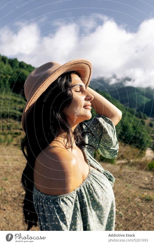 Junge Frau steht in den Bergen und genießt die Natur Reisender Sonnenlicht Berge u. Gebirge Landschaft Urlaub Tourismus Freiheit jung Harmonie Strohhut