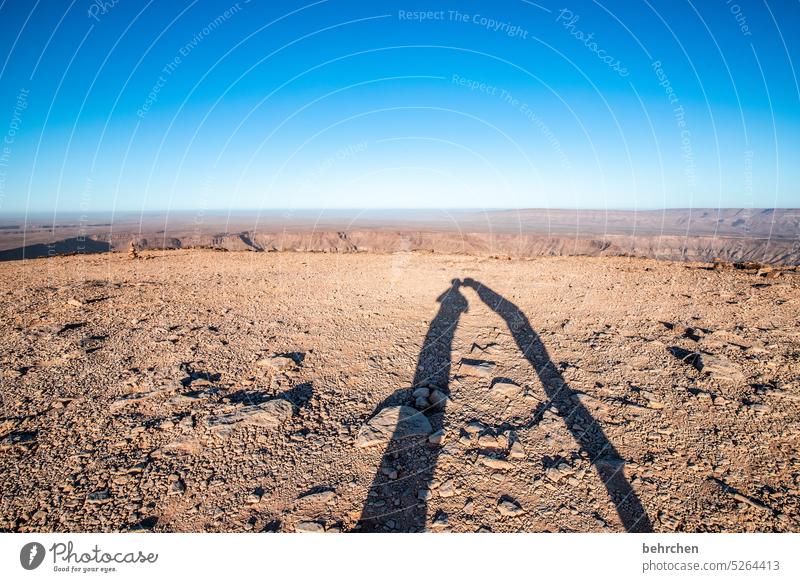 knutschen auf dem mond Paar Farbfoto Liebe Zusammensein Außenaufnahme zusammen gemeinsam Schatten Sonnenlicht Landschaft Abenteuer Himmel Blauer Himmel