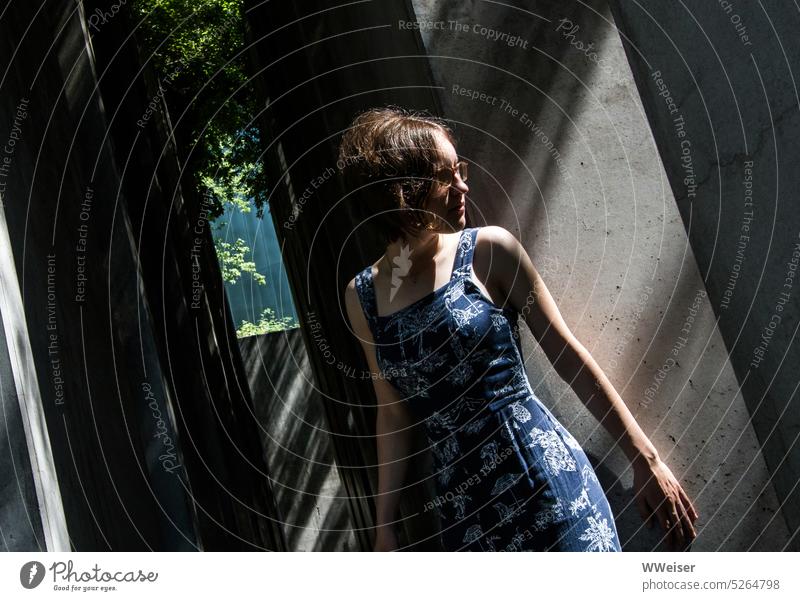 Eine junge Frau scheint sich hinter einer Mauer zu verstecken und angespannt abzuwarten Mädchen Sonnenbrille Sommer sommerlich Wände Stelen Säulen anlehnen