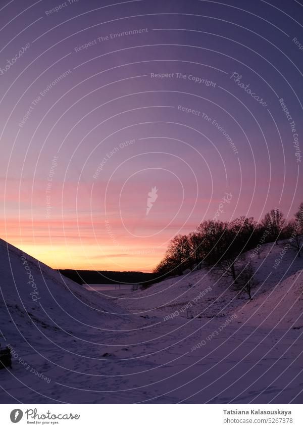 Rosa-violetter Sonnenuntergang über schneebedeckten Hügeln in Kernavė Litauen im Winter rosa purpur blau rosa Himmel rosa Sonnenuntergang farbenfroh bunt Abend