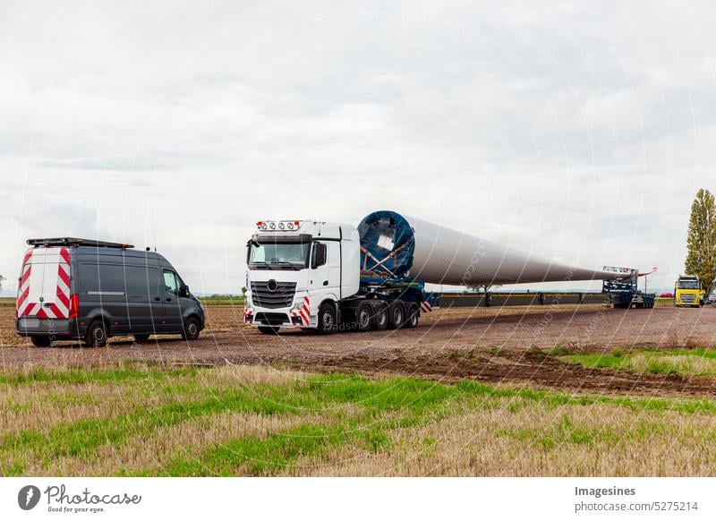 LKW auf dem Feld. Rotorblatt für Windkraftanlage. Spezialtransport eines Flügels für eine Windkraftanlage auf einem speziellen Sattelauflieger Auflieger