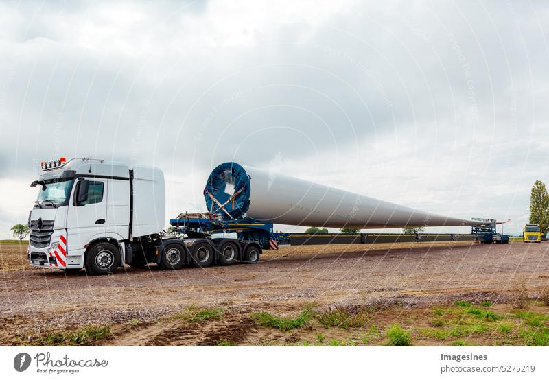 LKW auf dem Feld. Rotorblatt für Windkraftanlage. Spezialtransport eines Flügels für eine Windkraftanlage auf einem speziellen Sattelauflieger Auflieger