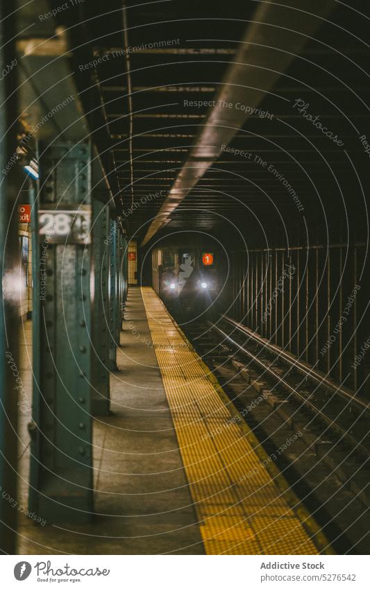 Zug auf Bahnsteig im Untergrund Eisenbahn Öffentlich U-Bahn Verkehr Abend unterirdisch alt Fahrzeug Metall leuchten Bewegung Wagen Stollen Scheinwerfer Station