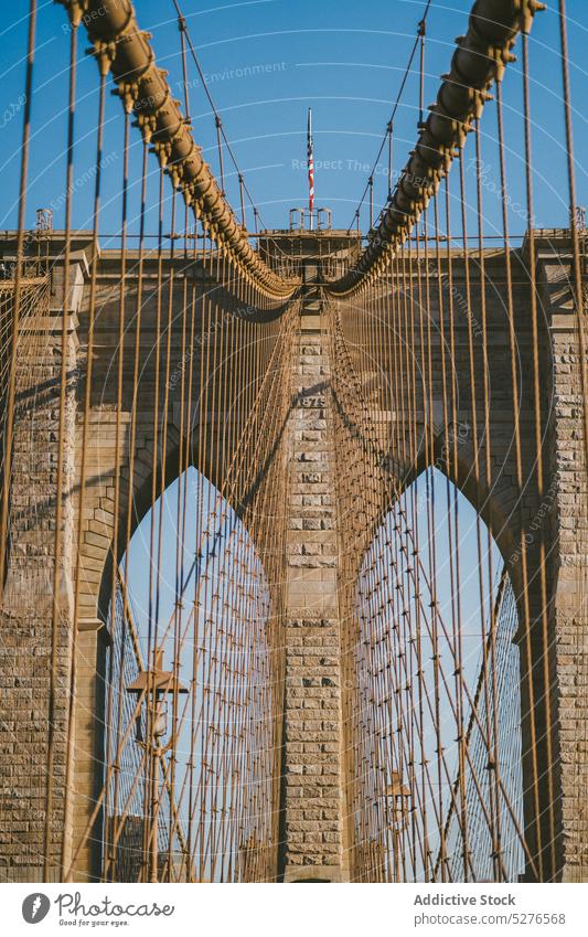 Brooklyn Bridge mit der Flagge der USA an der Spitze Fahne Stadtbild Megapolis Großstadt Gebäude Himmel Fluss Architektur Wolkenkratzer Stadtzentrum wolkig