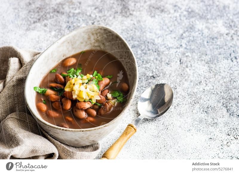 Bohnengemüsesuppe in der Schale serviert Hintergrund Beton Koriander Küche Schüssel Speise essen Essen erstes Gericht Lebensmittel Knoblauch Feinschmecker Kraut